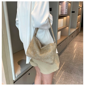 Close-up of sparkling gold rhinestone mesh shoulder bag on model for evening events