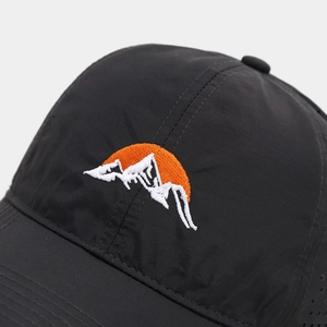 Close-up of sunrise and mountain embroidery on a breathable black outdoor baseball cap