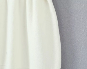 Dettaglio del tessuto a maglia a coste bianco che mostra la trama verticale elastica