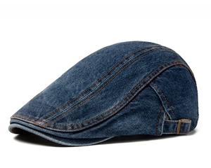 Close-up of dark blue denim beret with orange contrast stitching and adjustable metal buckle