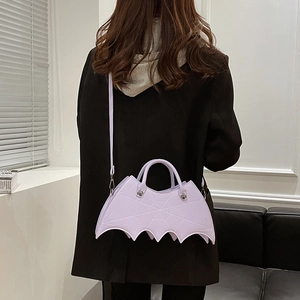 Woman wearing lavender bat-wing shaped PU leather crossbody bag over a black blazer