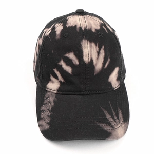 Détail de la casquette tie-dye en coton noir et beige avec une visière surpiquée