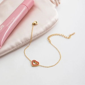 Elegant gold stainless steel bracelet featuring a red enamel double heart pendant