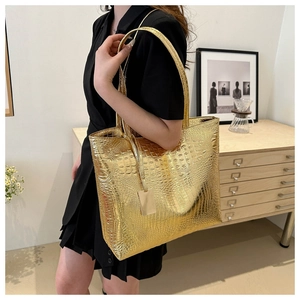 Chic golden crocodile pattern tote bag shown on model with black dress in lifestyle setting