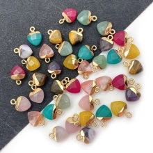 Macro shot of assorted colorful heart-shaped crystal pendants with gold bails and metal loops
