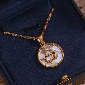 Close-up of 18K gold-plated sun and moon necklace with white pearl and crystals