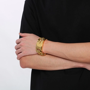 Dettaglio dell'ampio bracciale a catena cubana dorata da 31mm sul polso dell'uomo
