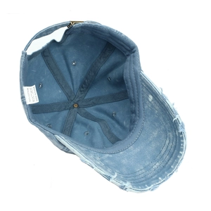 Distressed blue washed cotton baseball cap showing interior stitching and 100% cotton label