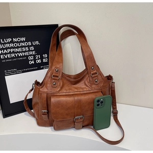 Detail of a brown PU leather tote bag with functional pockets and adjustable shoulder strap