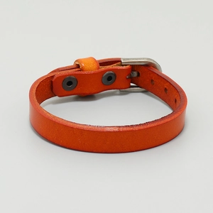 Detail view of orange leather bracelet with metallic buckle and adjustable holes