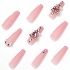 Pink gradient press-on nails with heart rhinestones and pearl accents in a set of 10