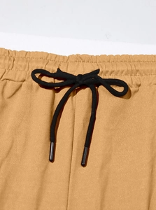 Detail of mustard yellow jogger waistband with elastic gathers and black drawstring