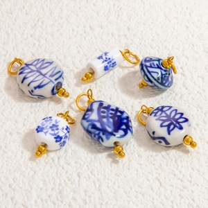 Blue and white porcelain pendant set with gold metal accents on stone background