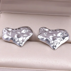 Detail of silver heart earrings with hammered metal texture in a jewelry box