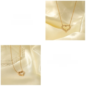 Macro detail of 18K gold hollow heart pendant necklace with zircon stones on satin