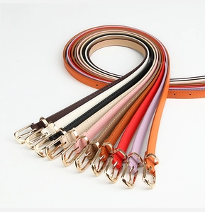 Close-up of assorted thin PU leather belts with gold buckles in various vibrant colors