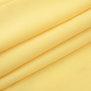 Gros plan détaillé du tissu jaune avec une texture fine et des plis plissés élégants