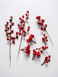 Close-up of deep red artificial holly berries on stems for festive DIY decorations