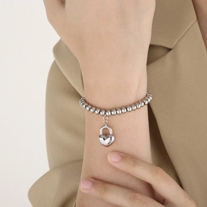 Minimalist silver stainless steel bead bracelet featuring a heart lock pendant on model