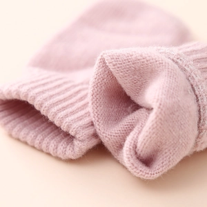 Detail of pink knitted baby hat cuff showing soft ribbed wool texture and premium craftsmanship