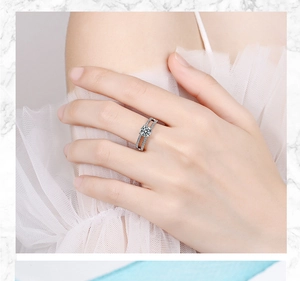 Detail of silver double-band zircon ring worn by a model against marble texture