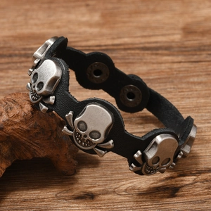Macro shot of vintage skull charms on black leather punk bracelet with snap button closure