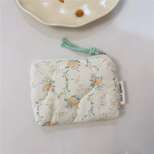 Close-up of floral quilted cotton pouch with zipper and simple wish label