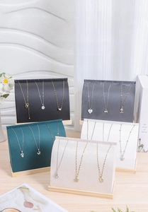 Detail of velvet necklace display stands with natural wood bases in multiple elegant colors