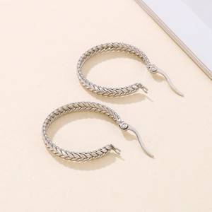 Detailed view of silver braided hoop earrings with intricate metallic twisted texture
