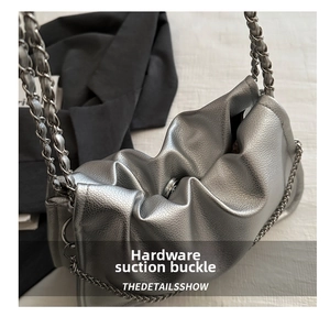 Detail of silver textured leather bag featuring metallic magnetic closure and chain strap