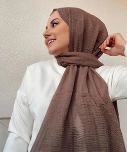 Detail of coffee brown crinkle scarf texture on model showing elegant hijab draping style