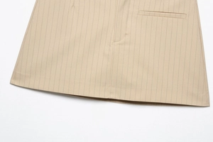 Details des beige gestreiften Rocks mit sauberer Saumnaht und falschem Taschendesign