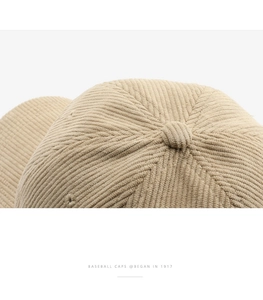Macro shot of beige corduroy texture and stitching on top of the baseball cap