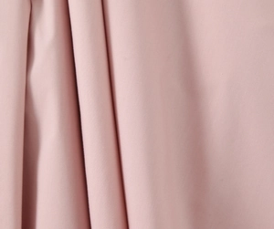 Gros plan sur la texture du tissu plissé rose pour la robe de style princesse