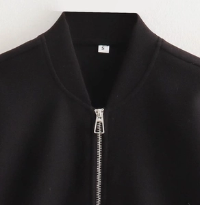 Detail of silver metal zipper and stand-up collar on a black casual bomber jacket