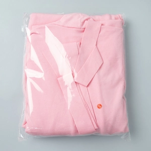 Detailed view of pink knitted cardigan set folded in transparent polybag with size S tag