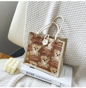 Close-up of a burlap lunch bag featuring a cute bear print and white rope handles