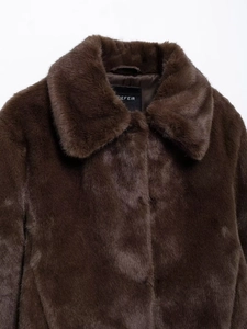 Close-up of deep brown faux fur coat showing dense texture and collar with brand label