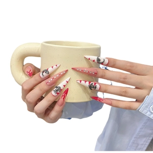 Handmade press-on nails with red flame patterns and vintage metal charms on long stiletto tips