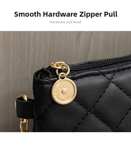 Détail de la fermeture éclair ronde dorée sur un sac à main noir en cuir matelassé