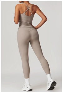 Dettaglio dei leggings yoga taupe a vita alta con cintura a V e reggiseno sportivo incrociato