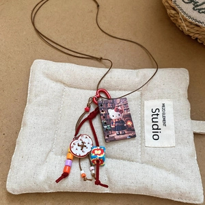 Close-up of handmade resin pendant with Hello Kitty motif and colorful beads