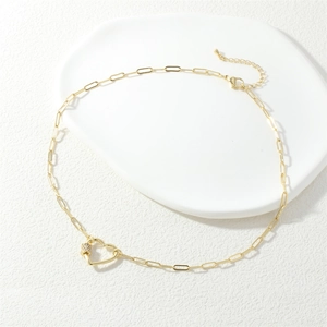 Gold heart pendant necklace with zircon accents and rectangle link chain on tray