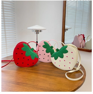 Detailed view of red pink and white strawberry shaped bags with sequin leaf accents