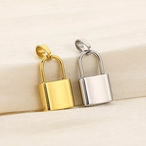 Detailed close-up of polished gold and silver stainless steel padlock pendants on fabric