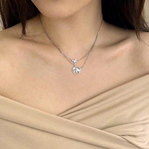 Detail of S925 sterling silver layered necklace with airplane and hollow world map charms
