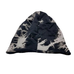 Close-up of black and white tie-dye knit beanie with rolled edge and soft texture