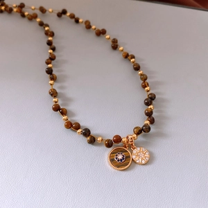 Détail du collier de perles en œil de tigre plaqué or 18 carats avec pendentifs