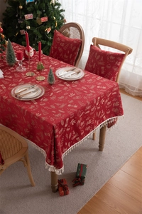Detail of red Christmas tablecloth with golden tassels and festive ho ho ho pattern