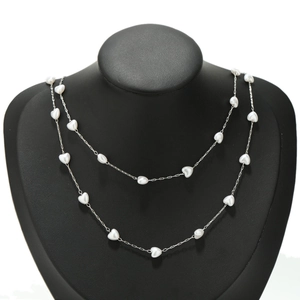 Detail of 18K gold-plated heart pearl chain on a black necklace display stand